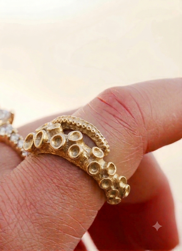 Octopus tentacle ring in 14k yellow gold, AI-rendered, shown worn on the hand