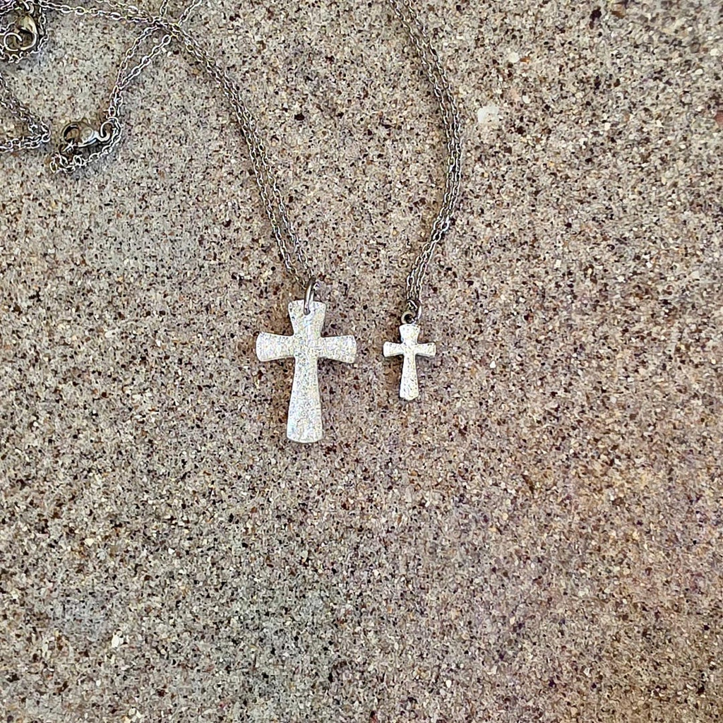 Woman wearing silver cross necklace with white shirt