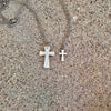 Woman wearing silver cross necklace with white shirt