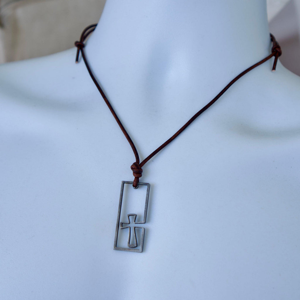 Leather cord cross necklace for men on a display bust, showing how the stainless steel surfer cross hangs on the adjustable cord