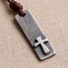 Close-up of the raised brushed silver cross welded onto the dark stainless steel bar, mens cross necklace detail
