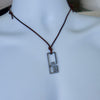 Surfer cross necklace for men shown on a display bust at a longer adjustable cord length, handmade stainless steel cross pendant