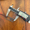 Digital caliper measuring the stainless steel cross necklace pendant at 1.64 inches long, a men's surfer cross on a wooden table