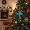 Turquoise Jesus cross ornament hanging on a Christmas tree