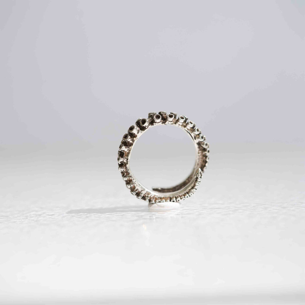 Small octopus tentacle ring in sterling silver, suction cup texture detail