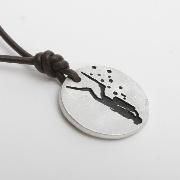 Seven eighths inch round pewter diver coin pendant on a black leather cord