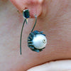 Close-up of brown diamond and pearl setting on octopus tentacle jewelry